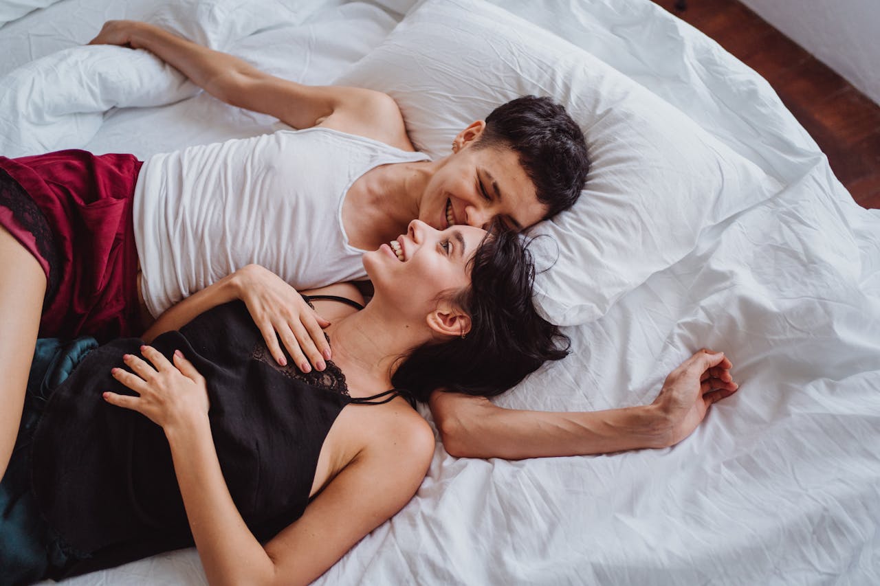 about-us-01 A joyful couple relaxing in bed, sharing intimate and happy moments together.